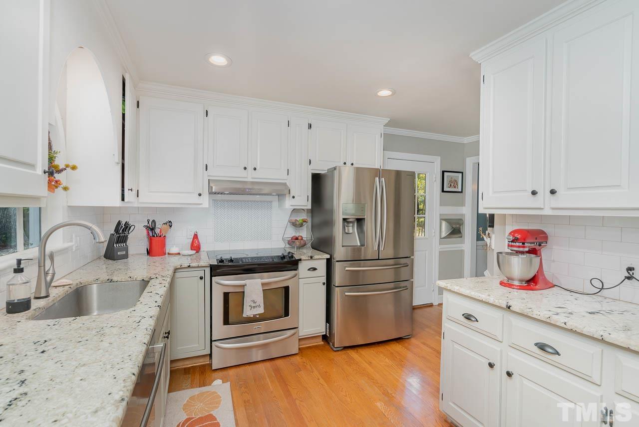 108 Donna Place Cary, NC 27513 - Photo 5 of 30 a kitchen with granite countertop a sink stainless steel appliances and cabinets