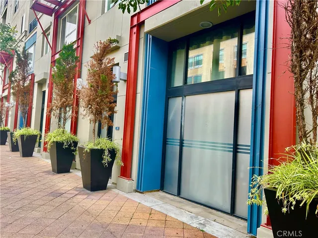 a view of a house with a potted plant and floor to ceiling window and potted plants