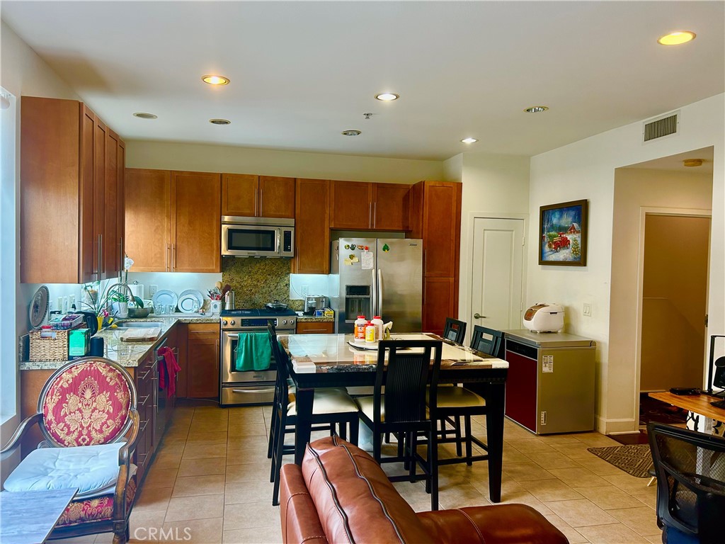 300 East 4th Street, Unit 101 Long Beach, CA 90802 - Photo 28 of 64 a view of kitchen with kitchen island dining table and chairs
