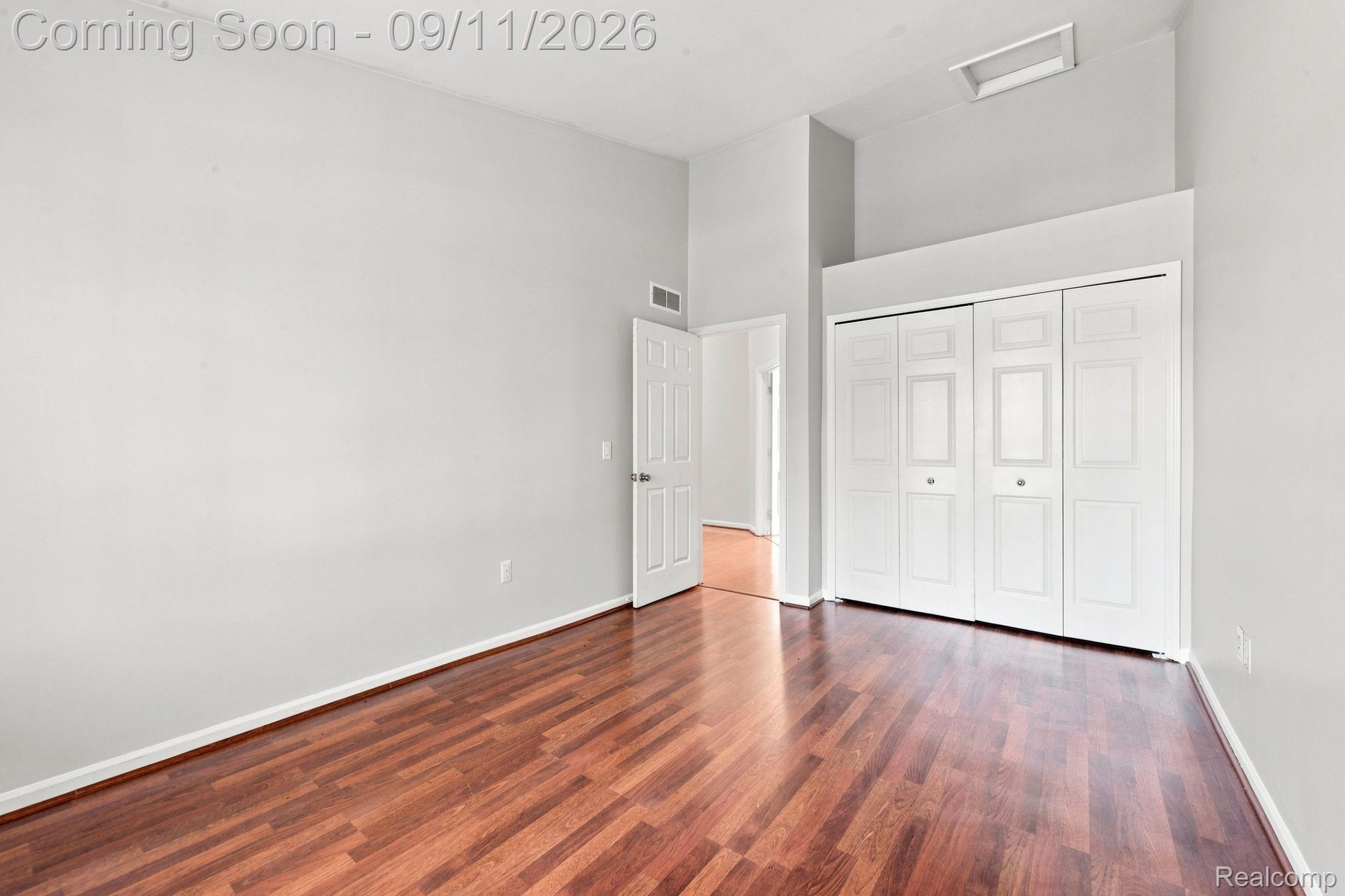 3201 Lynhurst Court Rochester, MI 48306 - Photo 28 of 43 Vaulted ceiling featuring a recessed light fixture, warm wood-finish flooring, white bi-fold closet doors, and white baseboards