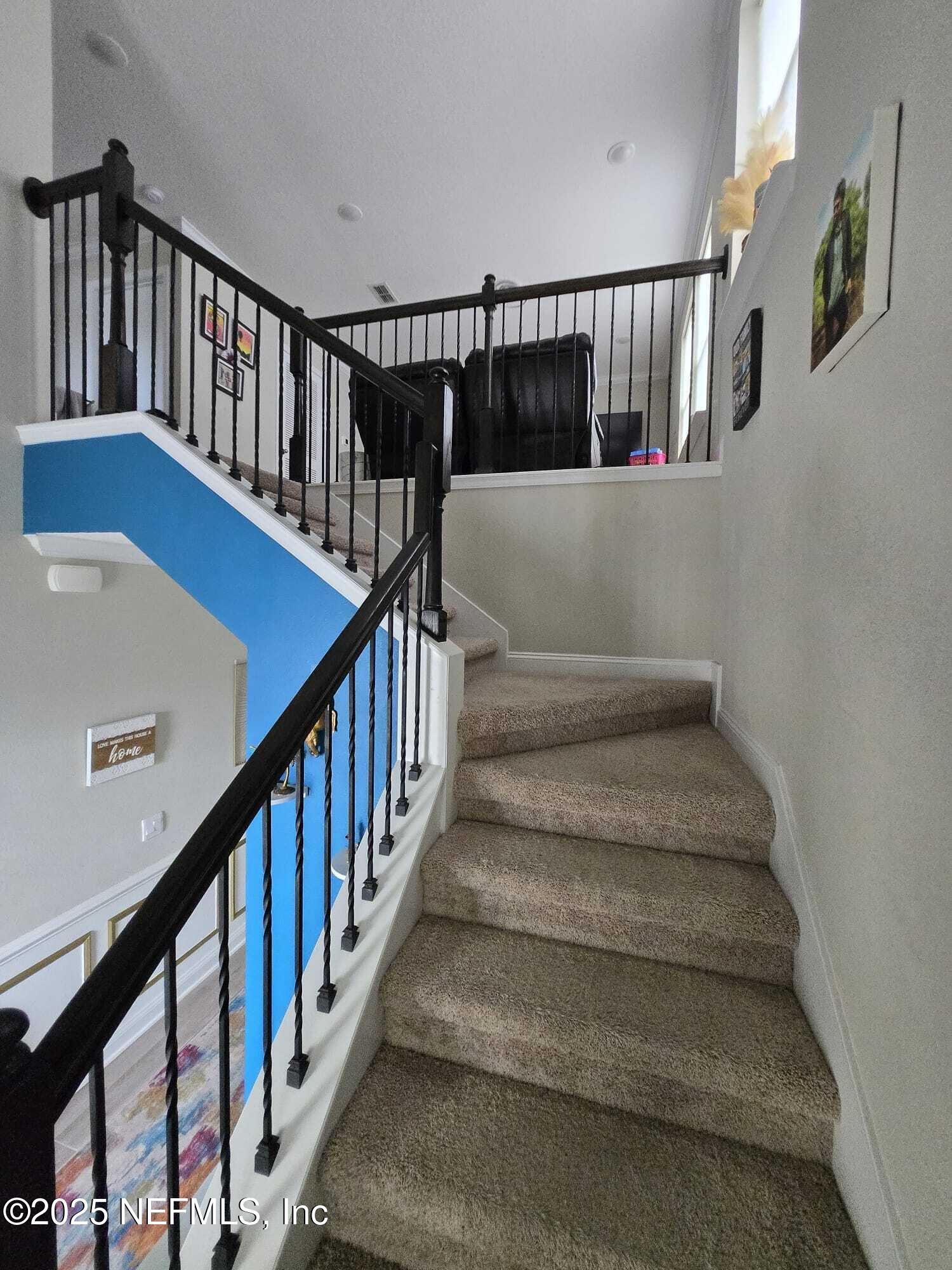 210 Thistleton Way Street St. Augustine, FL 32092 - Photo 14 of 38 a view of staircase with lots of frames on wall and wooden floor