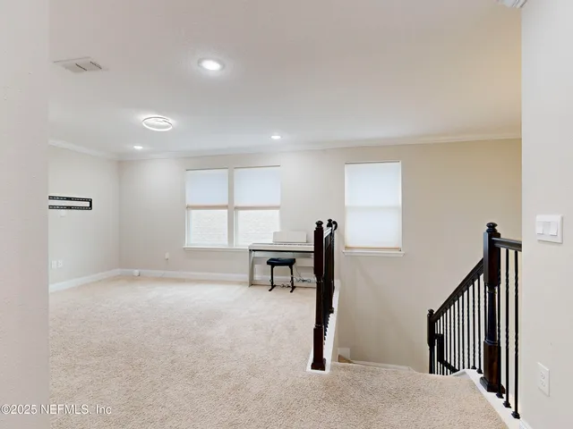a view of a room with windows and furniture