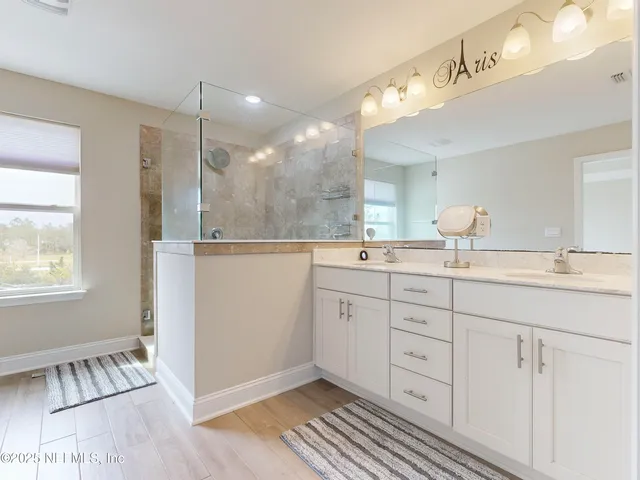 a bathroom with a sink a mirror and a shower