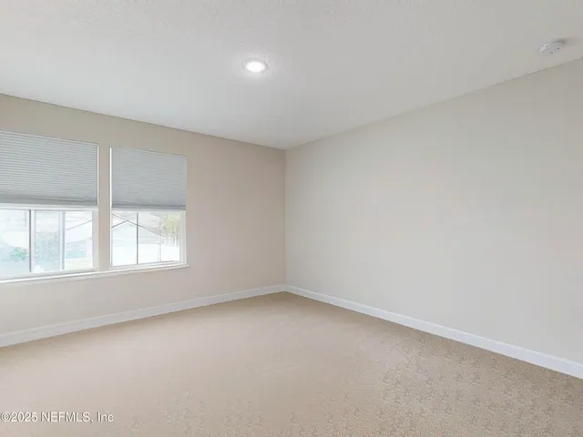 an empty room with a window and a ceiling fan