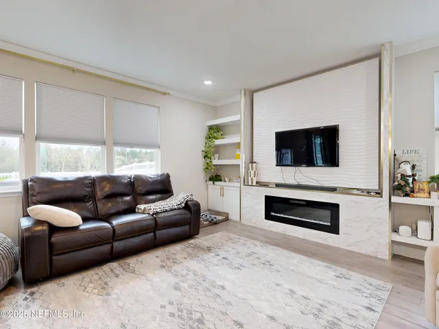 a living room with furniture a flat screen tv and a fireplace