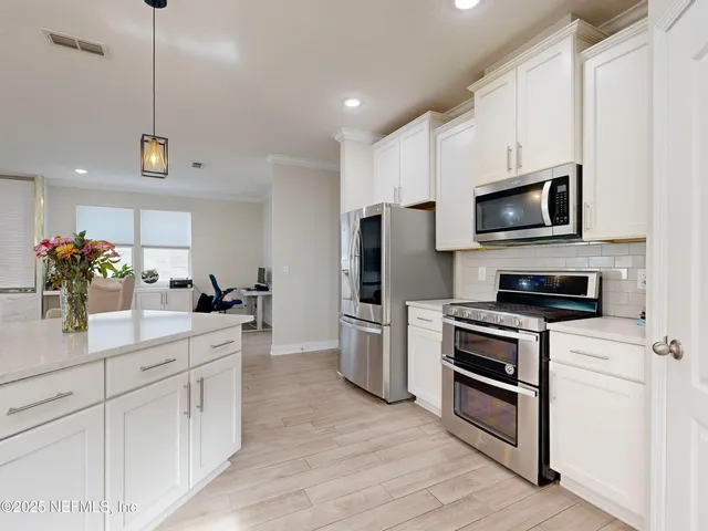 a kitchen with refrigerator a microwave a stove and cabinets