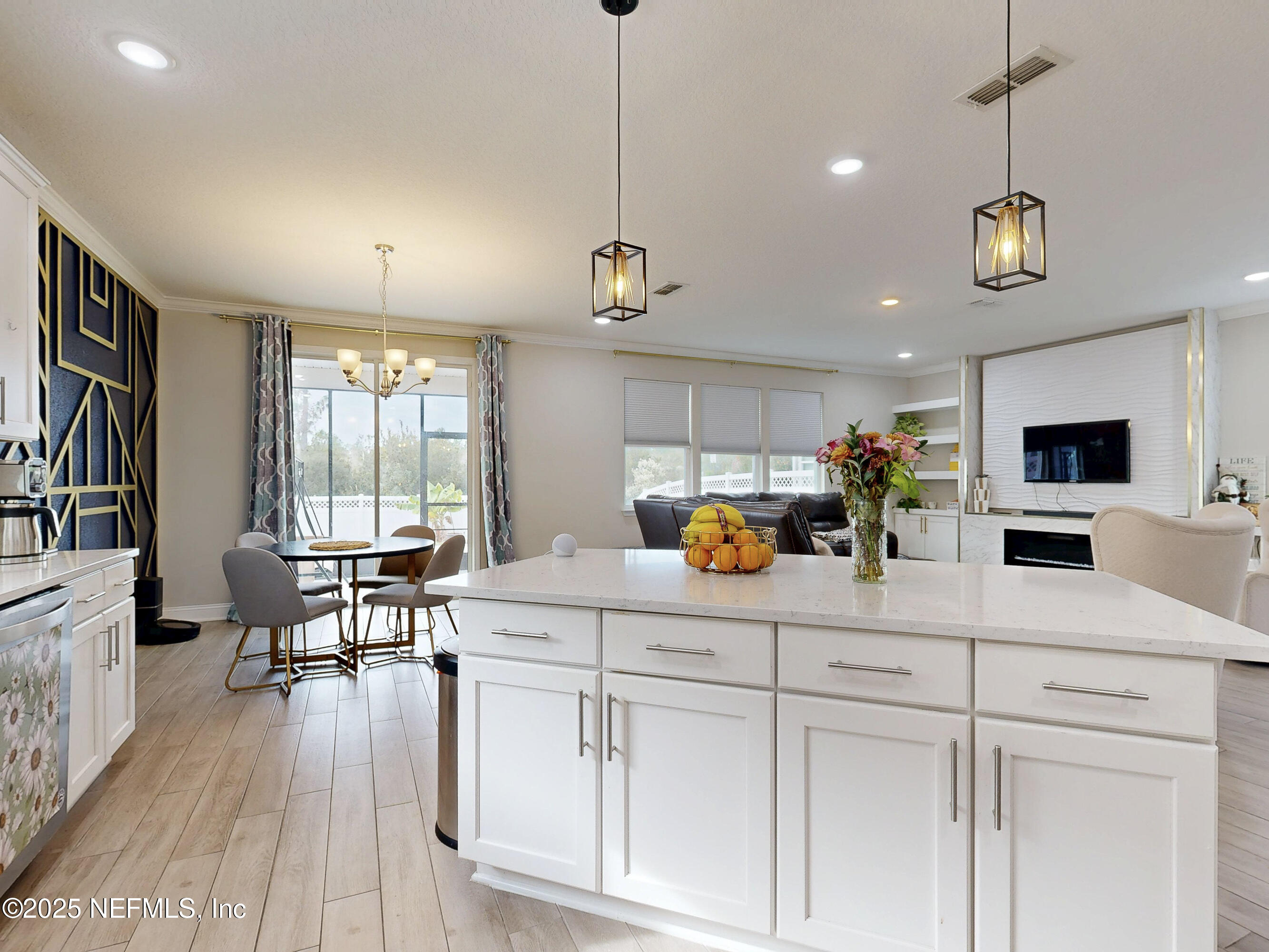 210 Thistleton Way Street St. Augustine, FL 32092 - Photo 9 of 38 a kitchen with stainless steel appliances kitchen island granite countertop a stove a sink a dining table and chairs with wooden floor