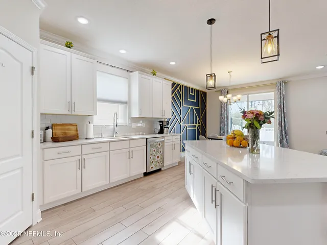 a kitchen that has a lot of cabinets in it and wooden floors