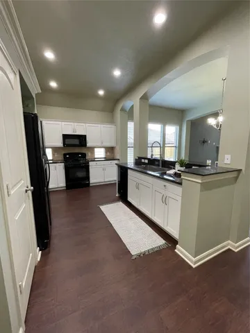a large white kitchen with refrigerator stove and a sink