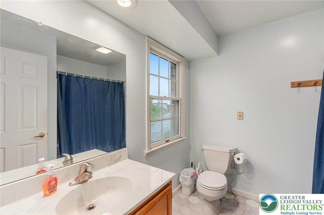 271 Maple Street Coplay, PA 18037 - Photo 15 of 25 a bathroom with a sink a toilet and shower curtain