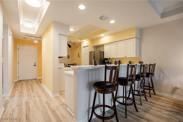 a kitchen with white cabinets and sink