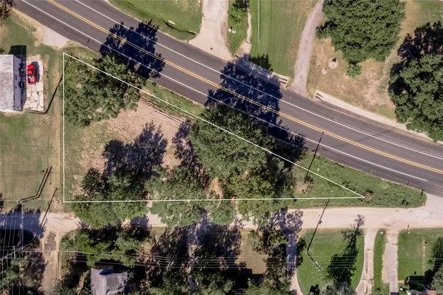 an aerial view of residential houses with outdoor space and trees