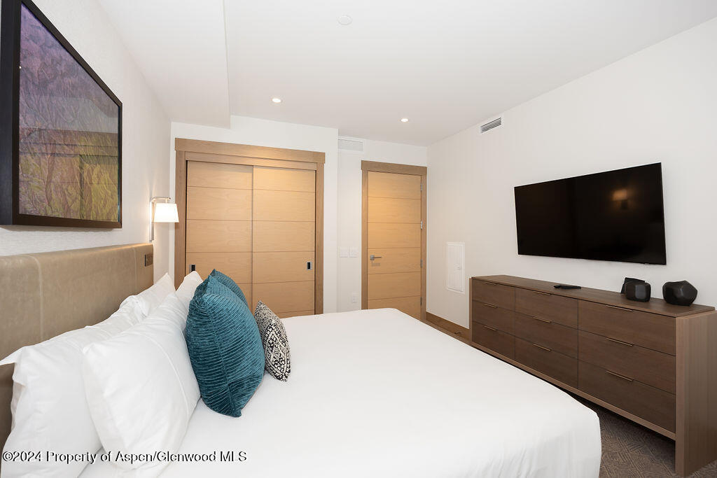 130 Wood Road, Unit 464 Snowmass Village, CO 81615 - Photo 13 of 19 a bedroom with a bed and a flat screen tv