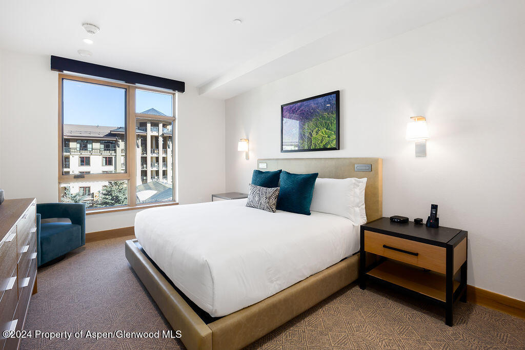 130 Wood Road, Unit 464 Snowmass Village, CO 81615 - Photo 14 of 19 a large bed sitting in a bedroom next to a window
