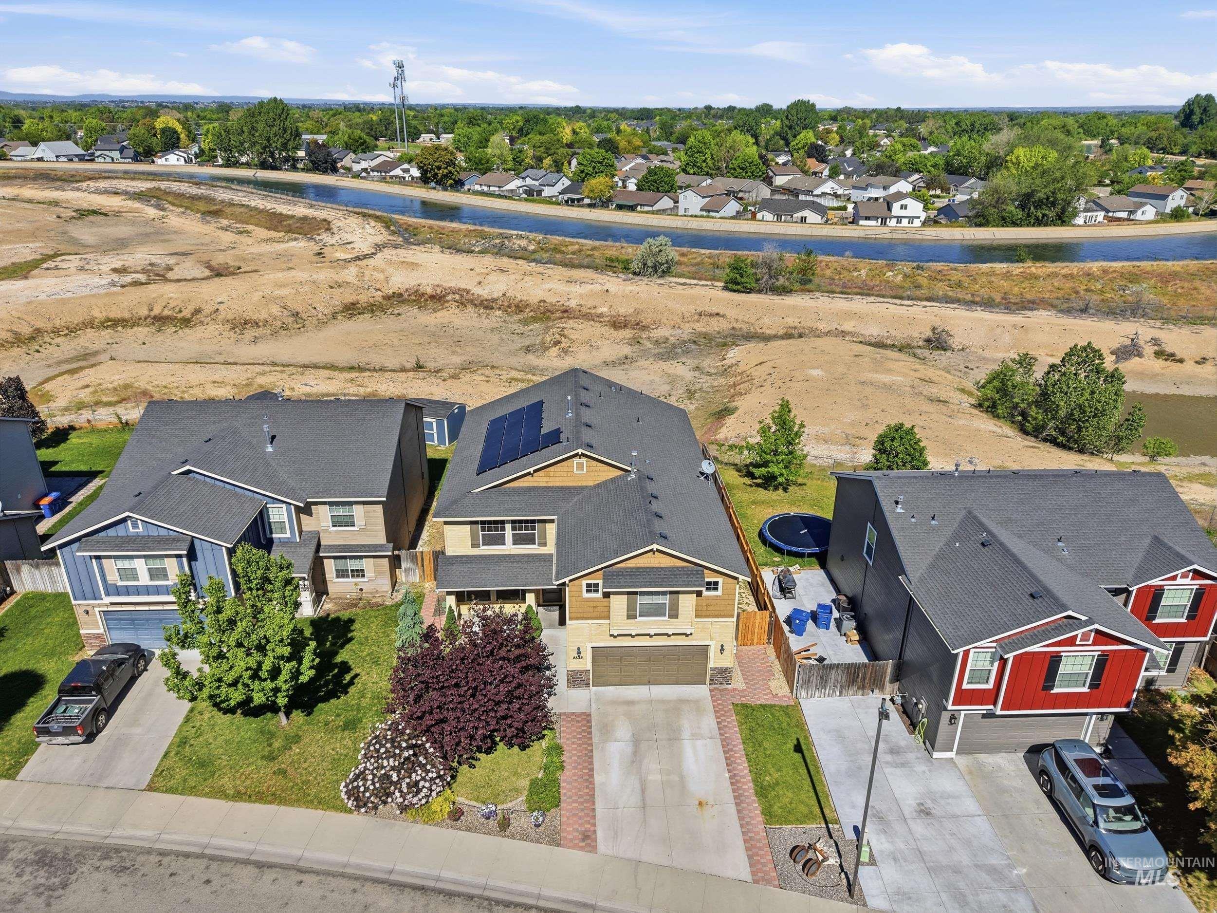4855 South Chex Way Boise, ID 83709 - Photo 32 of 47 Two-story home featuring a gabled roofline, solar panels, an attached garage, and a concrete driveway with brick pavers