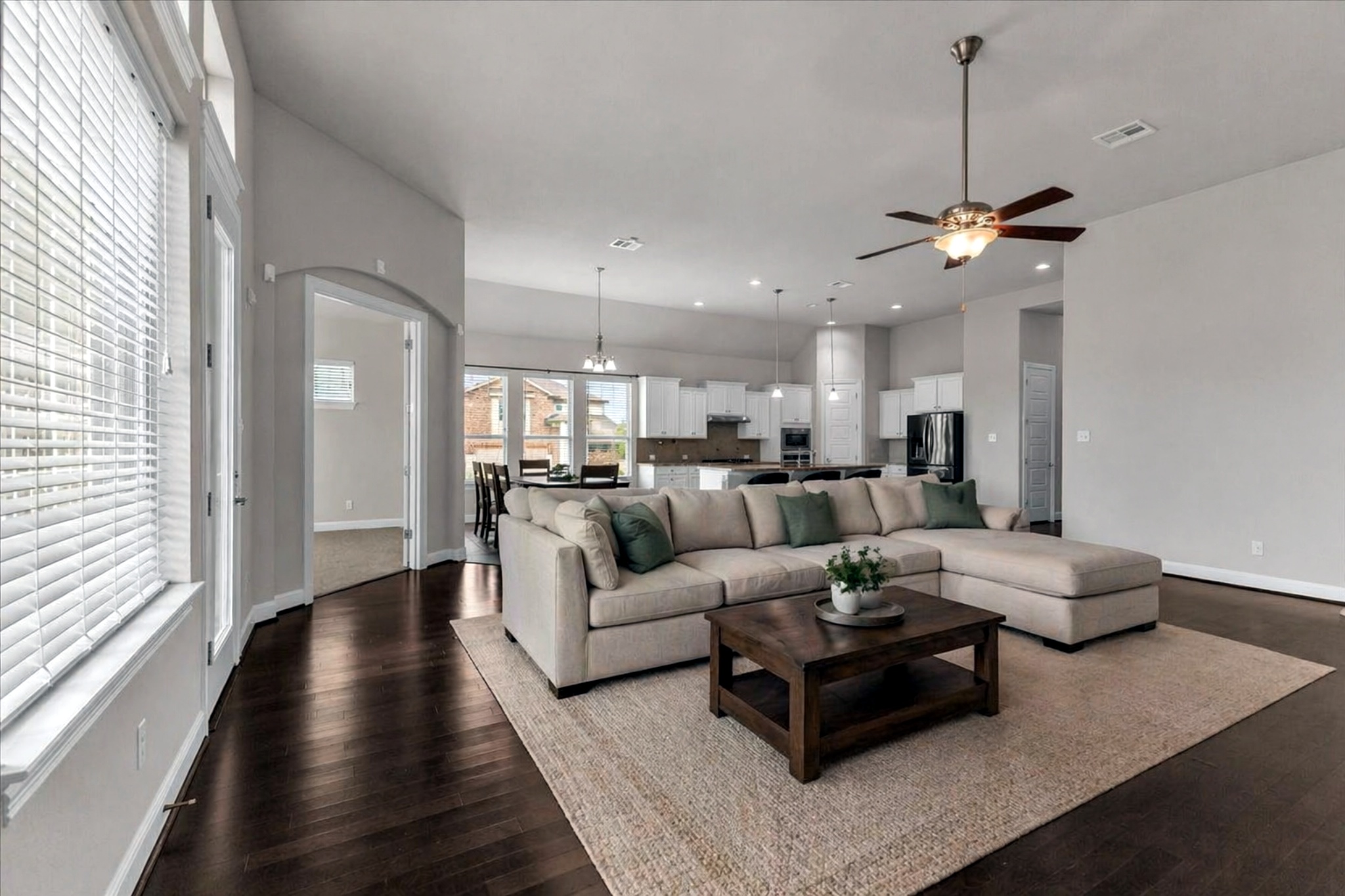 21301 Resource Road Pflugerville, TX 78660 - Photo 3 of 29 Open-concept living area featuring rich dark wood-finish flooring, a ceiling fan with integrated lighting, and high ceilings