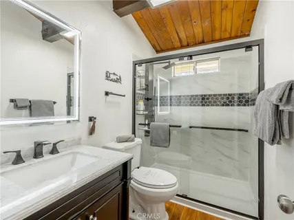 a bathroom with a sink a toilet and shower