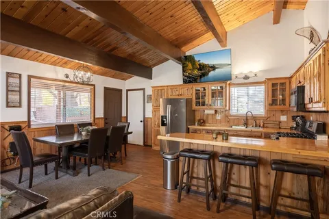 a dining hall with stainless steel appliances granite countertop a dining table and chairs with wooden floor