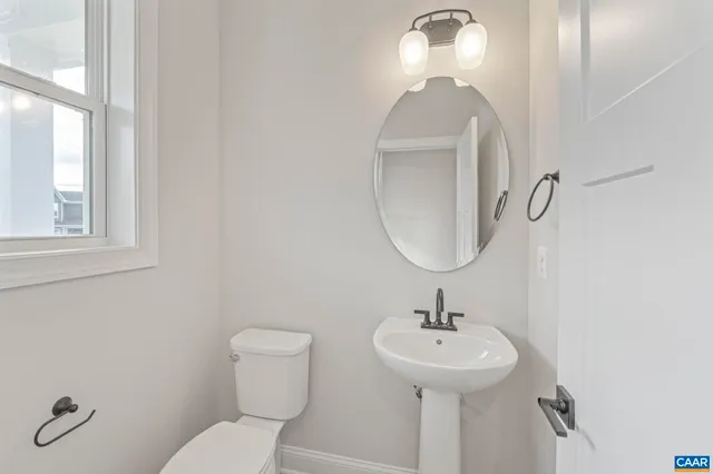 a bathroom with a toilet a sink and mirror