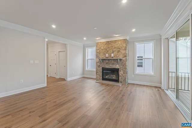 a view of a livingroom with wooden floor and a fireplace