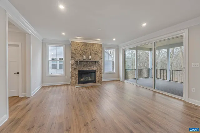 a view of empty room with wooden floor and fireplace