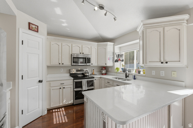 11189 Ohenry Road East Sandy, UT 84070 - Photo 8 of 44 Kitchen featuring white cabinetry with crown molding, stainless steel appliances, a double basin sink with a black fixture, and light-toned countertops