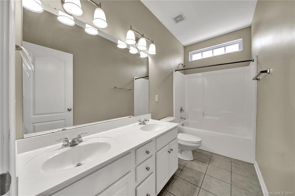 866 Treasure Court Fort Mill, SC 29708 - Photo 15 of 38 a bathroom with a double vanity sink a toilet and a mirror