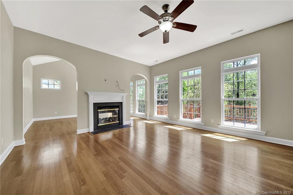 866 Treasure Court Fort Mill, SC 29708 - Photo 25 of 38 a view of an empty room with wooden floor and a fireplace
