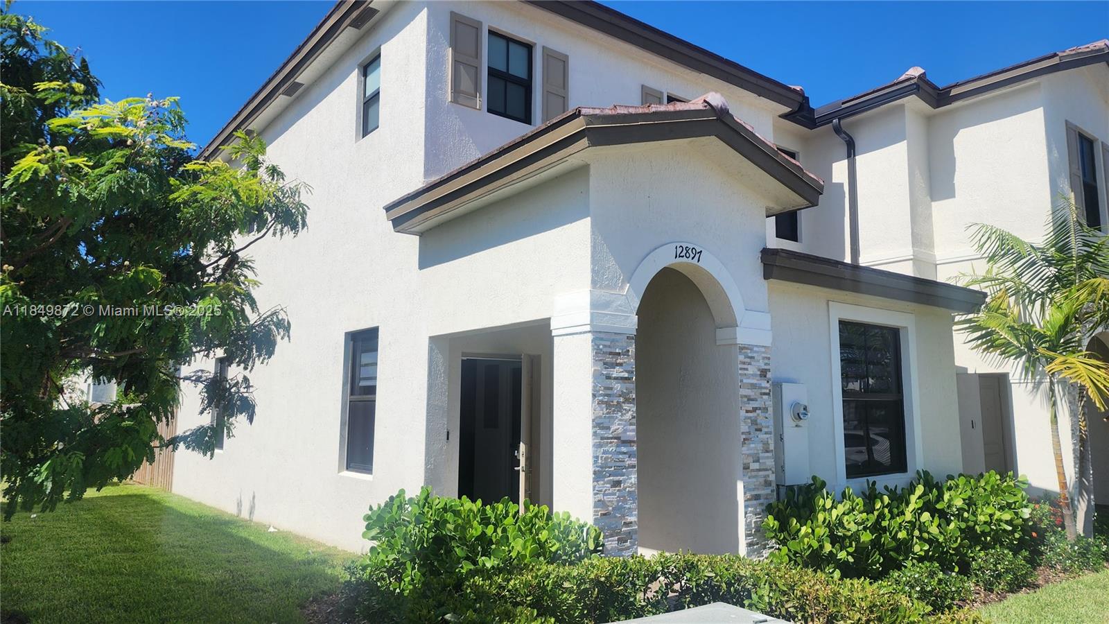 12897 Southwest 234th Street Homestead, FL 33032 - Photo 1 of 24 a front view of a house with garden