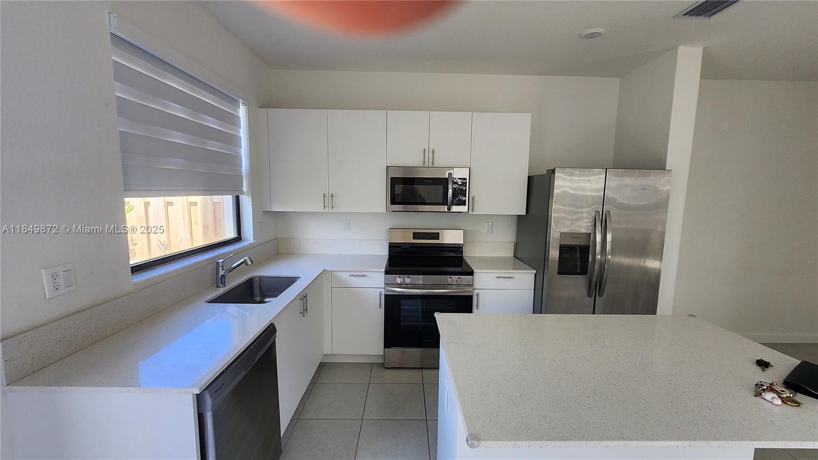 12897 Southwest 234th Street Homestead, FL 33032 - Photo 7 of 24 a kitchen with cabinets and steel appliances