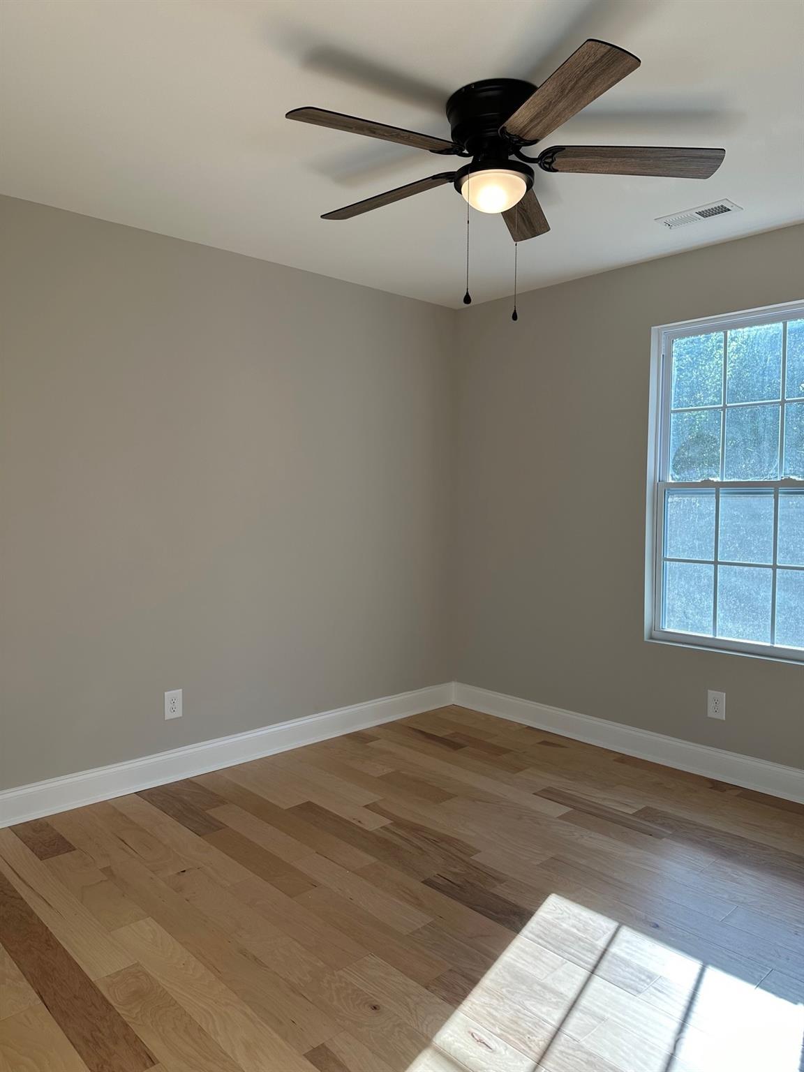 1091 Tryon Street Lancaster, SC 29720 - Photo 12 of 30 an empty room with wooden floor chandelier fan and windows