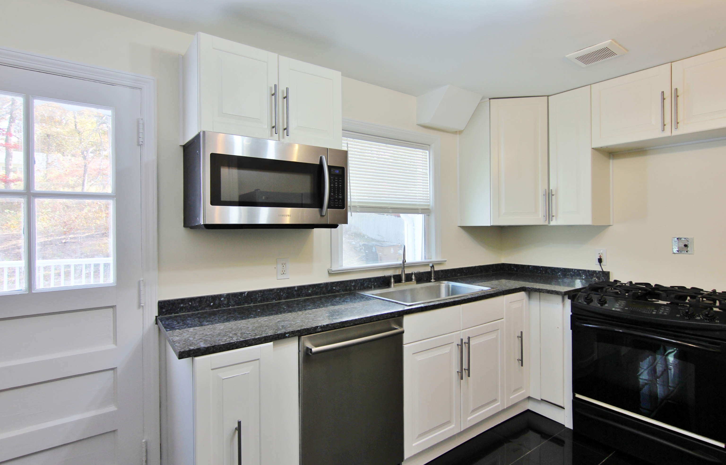663 High Ridge Road Stamford, CT 06905 - Photo 11 of 27 a kitchen with stainless steel appliances granite countertop a sink a stove a microwave and cabinets