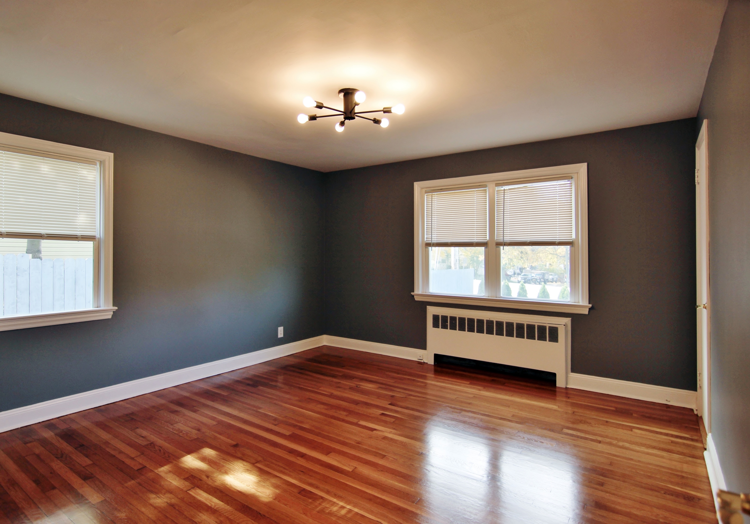 663 High Ridge Road Stamford, CT 06905 - Photo 16 of 27 an empty room with wooden floor chandelier and windows