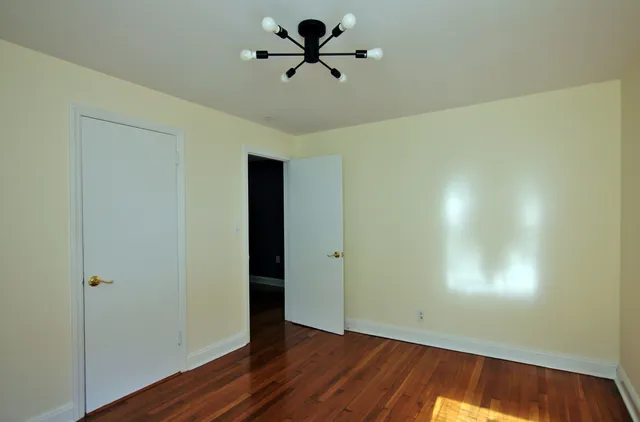 a view of a room with wooden floor and a ceiling fan