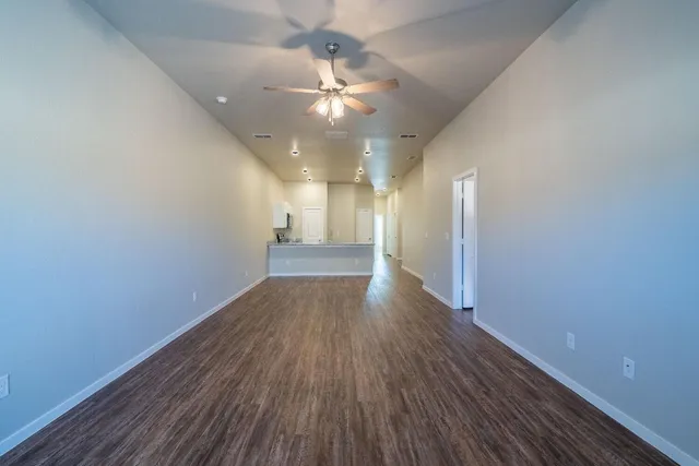 a view of a big room with wooden floor and windows in a room
