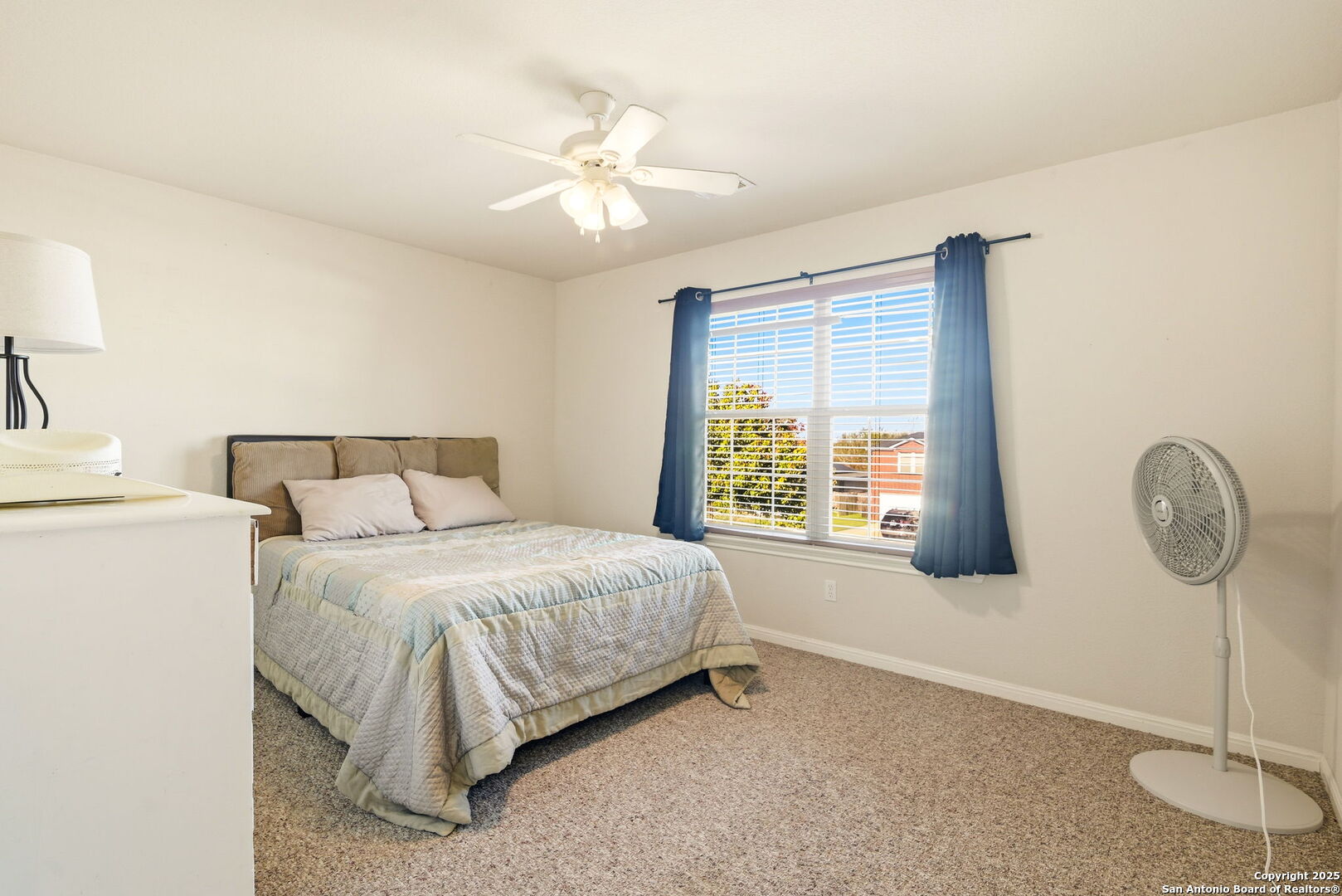 133 Falling Sun Cibolo, TX 78108 - Photo 17 of 28 a bedroom with a bed a chandelier and a window