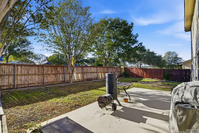 a view of a backyard with wooden fence