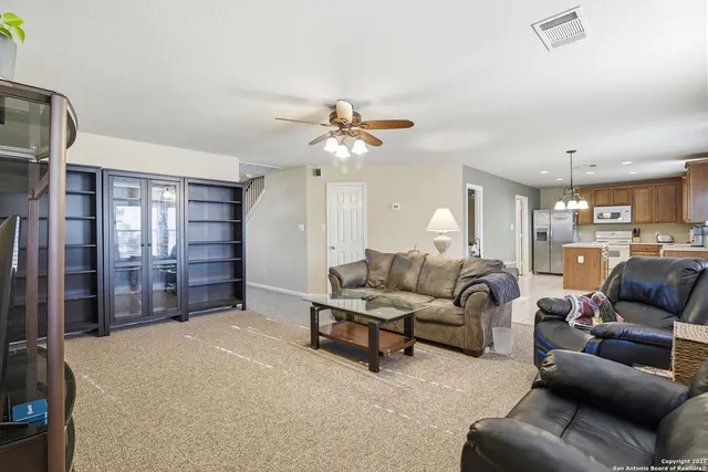 a living room with furniture a ceiling fan and a rug