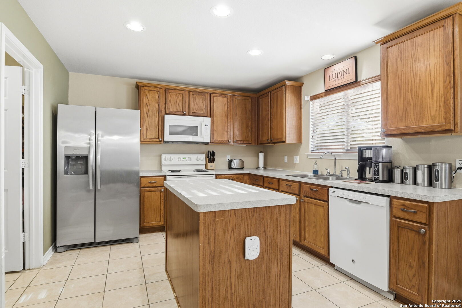 133 Falling Sun Cibolo, TX 78108 - Photo 9 of 27 a kitchen with stainless steel appliances granite countertop a sink stove refrigerator and cabinets
