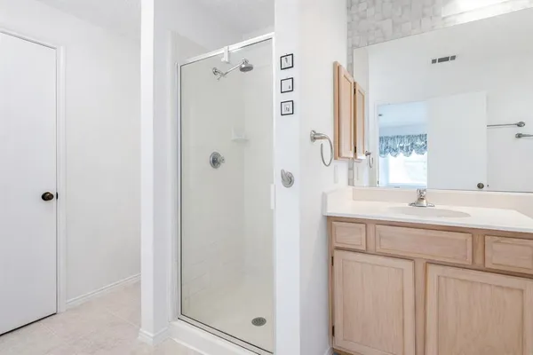 a bathroom with a shower sink and mirror