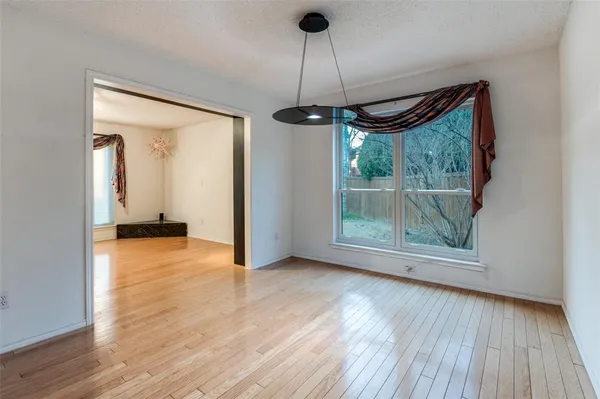 a view of a room with wooden floor a ceiling fan and window