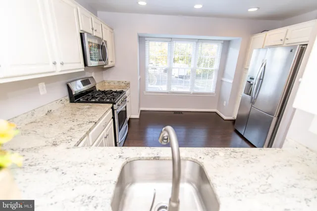 a view of a kitchen with wooden floor and a refrigerator