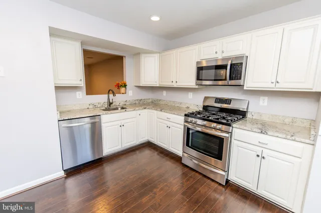 a kitchen with white cabinets stainless steel appliances and sink
