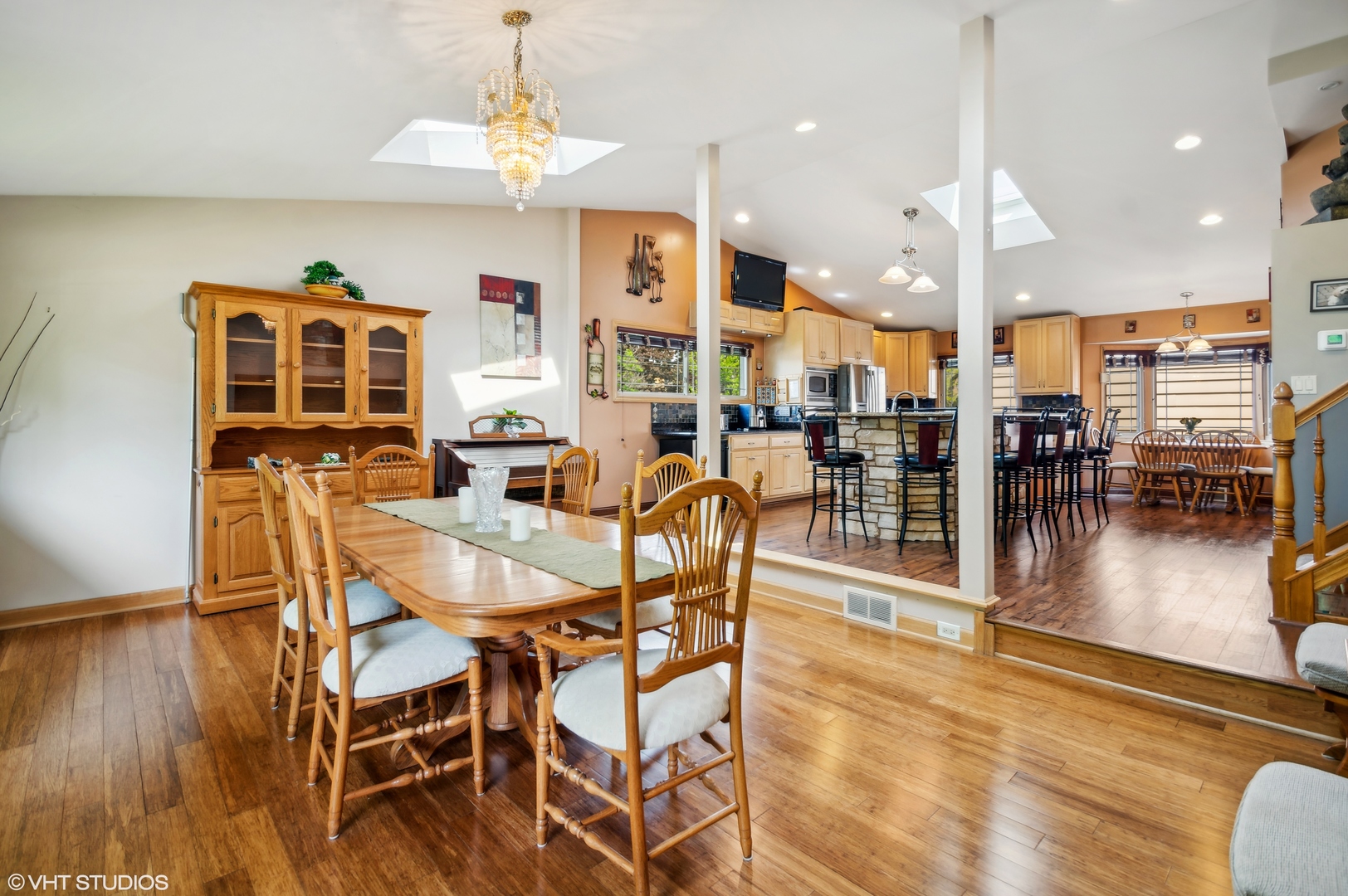 7962 Beckwith Road Morton Grove, IL 60053 - Photo 9 of 30 a dining room with wooden floor a chandelier a glass table and chairs