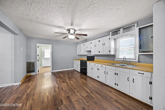 a large kitchen with granite countertop a large counter top space and stainless steel appliances