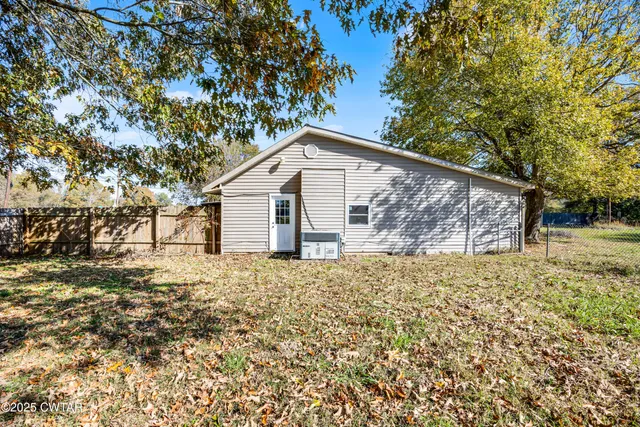 a white house that has tree in front of it