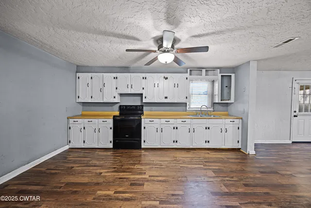 a kitchen with cabinets appliances and a ceiling fan