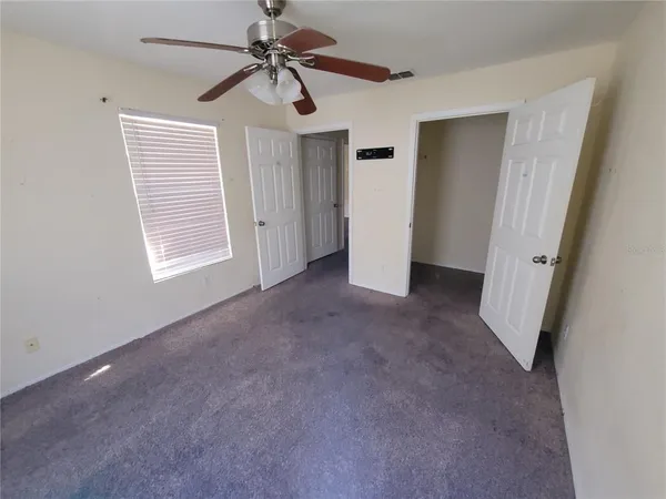 a view of a livingroom with a ceiling fan and window