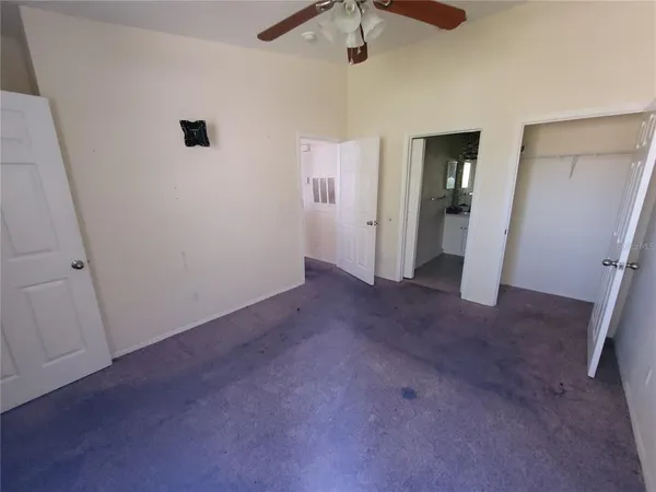an empty room with chandelier fan