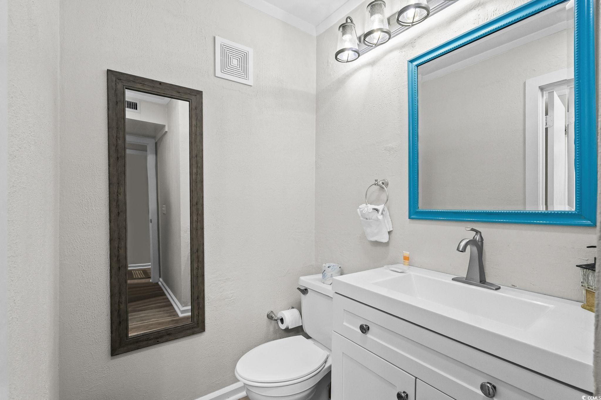 415 Ocean Creek Drive, Unit 2346 Myrtle Beach, SC 29572 - Photo 22 of 40 Half bathroom featuring vanity, a textured wall, and ornamental molding
